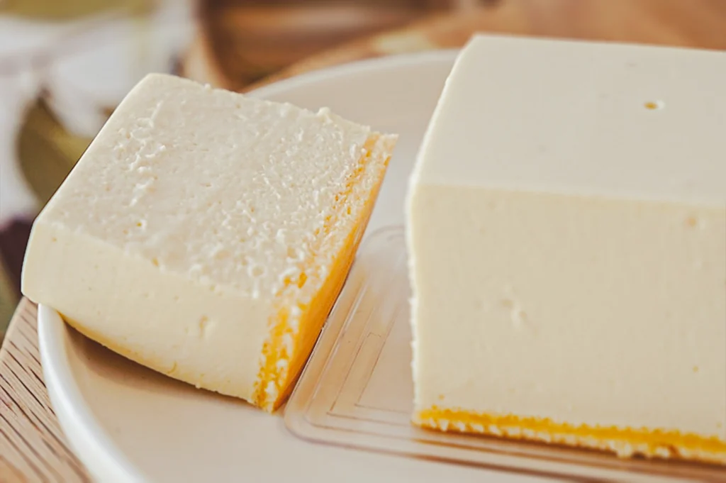 Tofu‑based cheesecake cut into clean slices, featuring a smooth dairy‑free creamy texture and light biscuit base, presented as a plant‑based dessert option