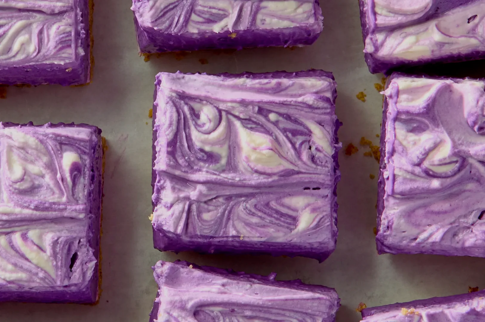 Purple swirled dessert bars arranged on a surface.