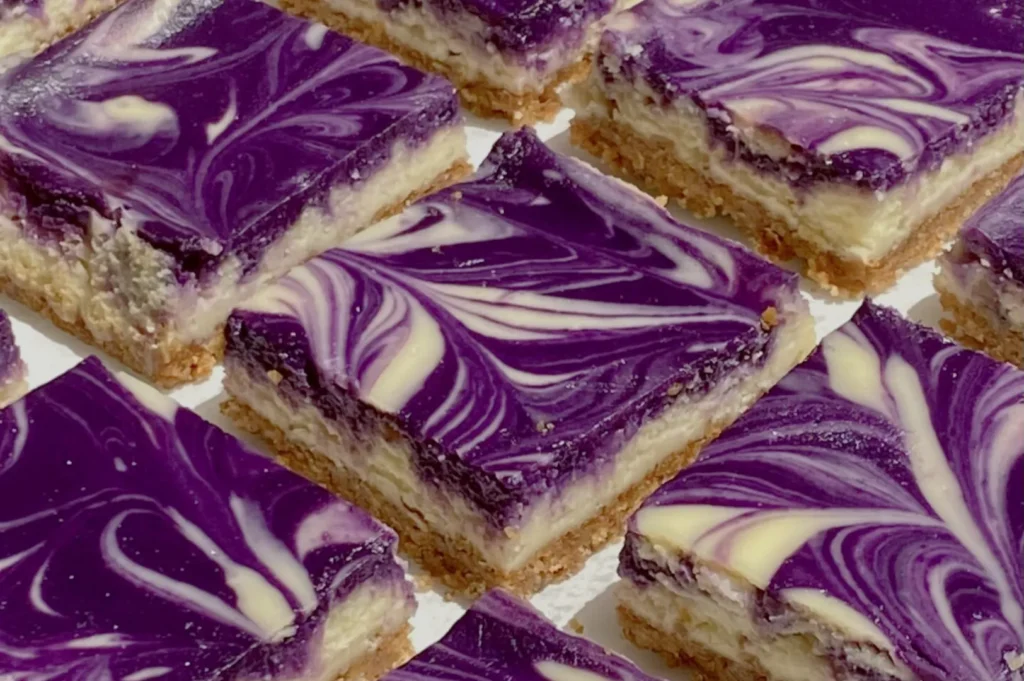 A close-up of purple and white swirled dessert squares arranged in a grid pattern.
