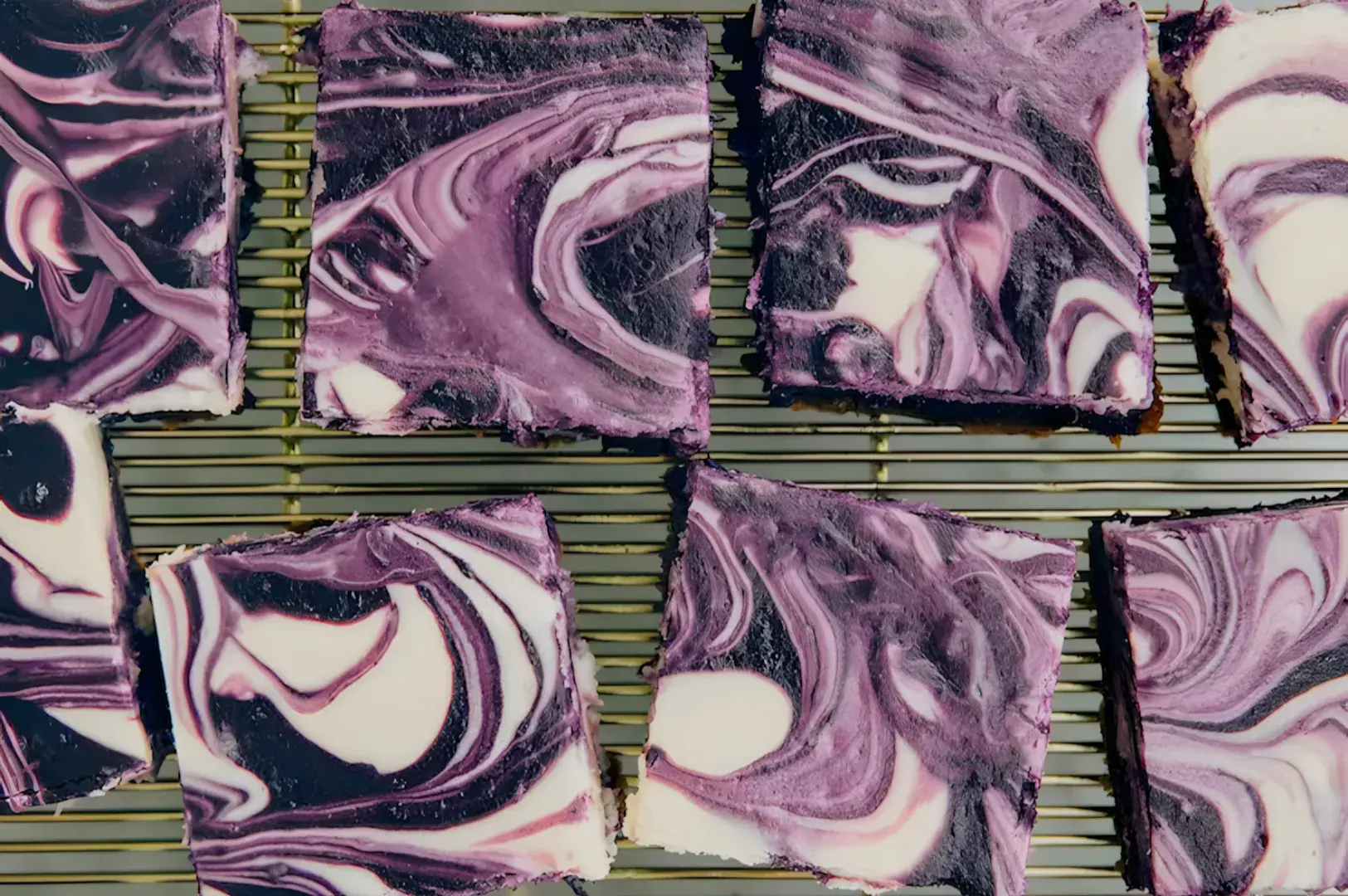 A tray of marbled purple and white dessert squares on a cooling rack.